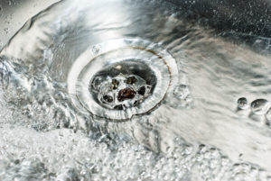 stainless steel sink plug hole close up with water