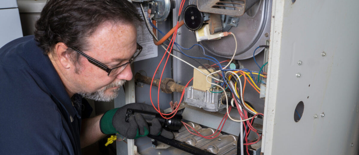 Technician Looking Over A Gas Furnace